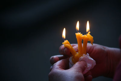 Lit candle in dark room