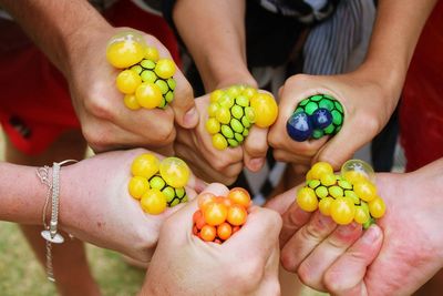 Friends squeezing stress balls together.