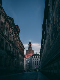 Low angle view of buildings in city against blue sky