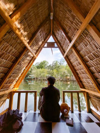 Rear view of man looking through window