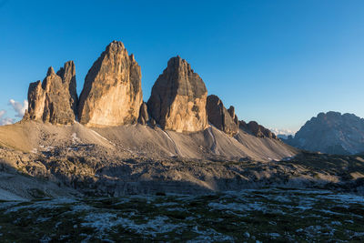 Panoramic view of rocky mountains against clear blue sky