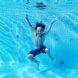 Shirtless boy swimming in pool