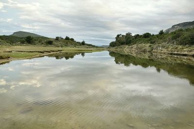 Scenic view of lake against cloudy sky