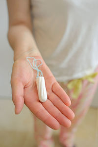 Close-up of woman hand holding tampon