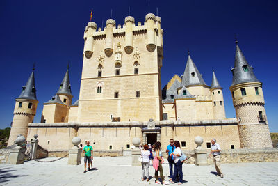 Group of people in front of building against clear sky