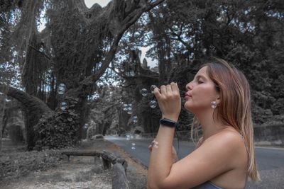 Side view of woman blowing bubbles