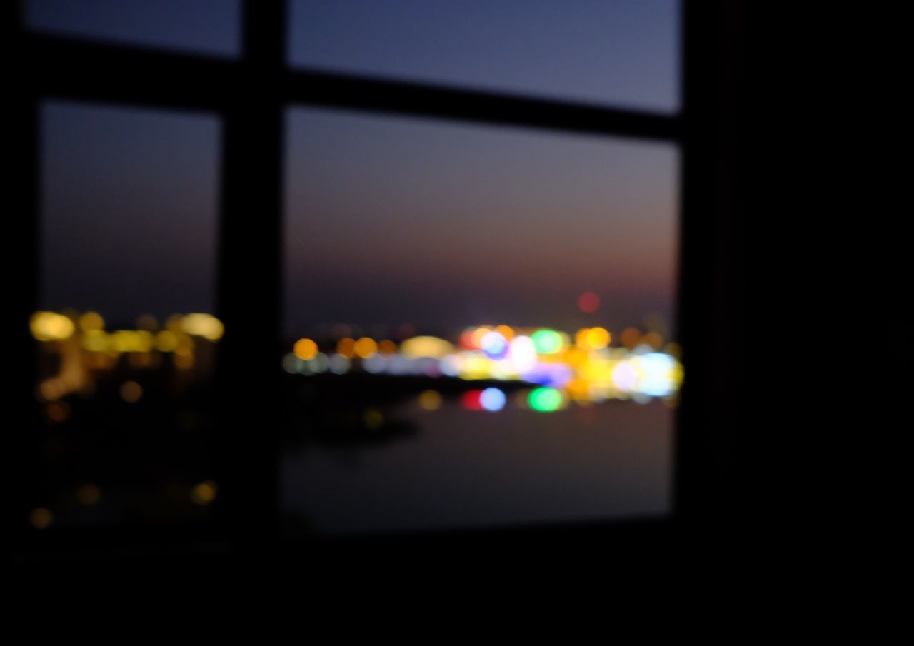 DEFOCUSED IMAGE OF ILLUMINATED LIGHTS AGAINST WINDOW