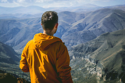 Rear view of man standing in mountains