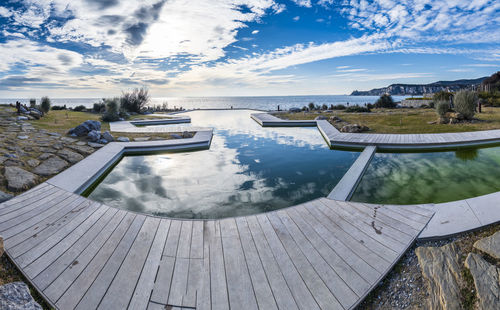 View of swimming pool against cloudy sky