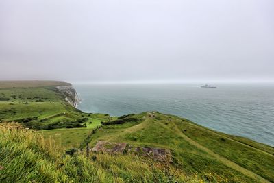 Scenic view of white cliffs of dover and sea against clear sky