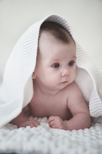 Portrait of cute baby lying on bed