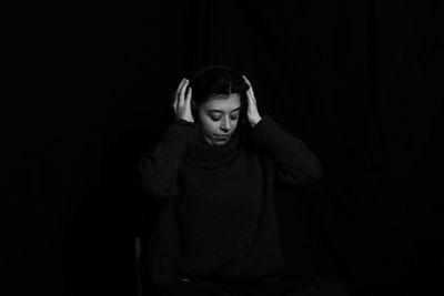 Young woman with head in hand in darkroom