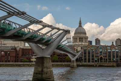 Bridge over river against buildings in city