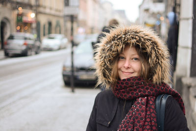 Portrait of woman wearing fur coat standing in city