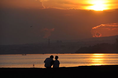 Silhouette of people at beach during sunset
