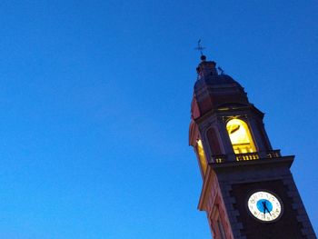 Low angle view of clock tower against blue sky