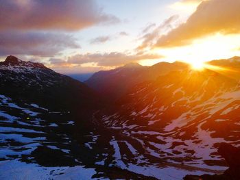 Sun shining through clouds over mountain
