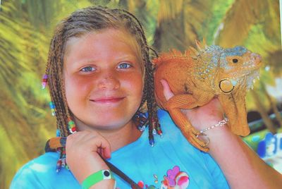 Close-up of young girl with iguana