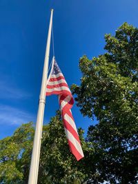 Low angle view of flag against blue sky