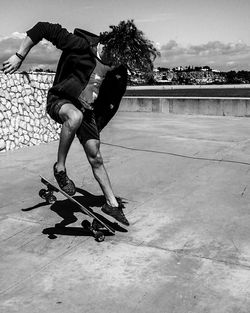 Full length of man performing stunt while skateboarding at park