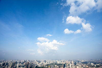 Aerial view of buildings against cloudy sky