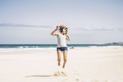 Full length of woman on beach against sky