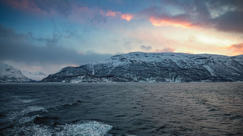 Scenic view of snowcapped mountains against sky during sunset