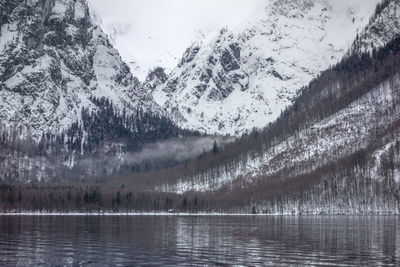 Scenic view of lake by snowcapped mountains during winter