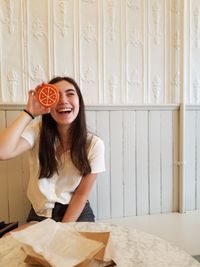 Young woman holding a cookie and laughing