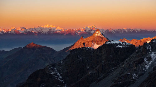 Scenic view of snowcapped mountains against sky during sunset