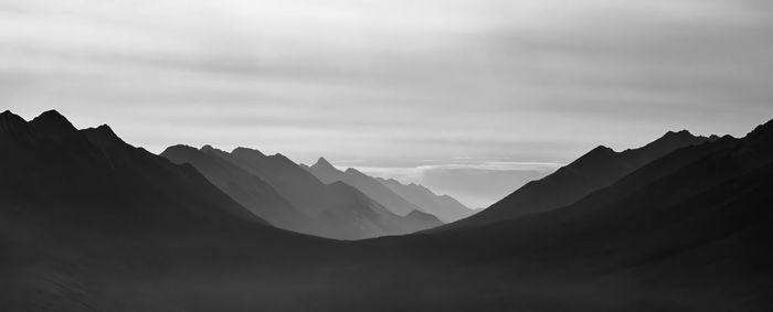 Scenic view of silhouette mountains against sky