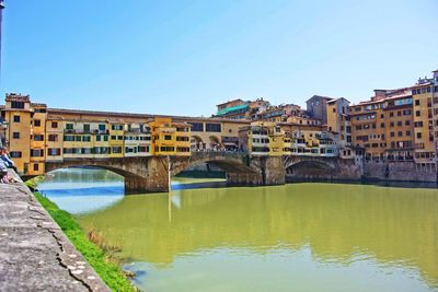 Ponte vecchio over arno river against clear sky