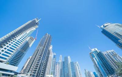Low angle view of modern buildings against clear blue sky