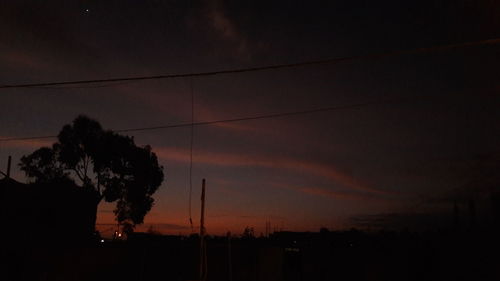 Low angle view of silhouette trees against sky at sunset