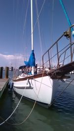 Sailboats moored on sea against sky