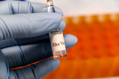 Cropped image of biologist holding zika vaccine at laboratory