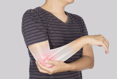 Midsection of woman holding paper against white background