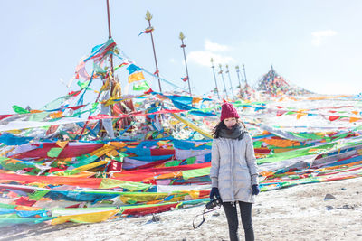 Portrait of woman standing against prayer flags in city