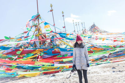 Full length of young woman standing against the sky