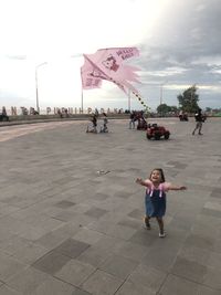 People on street in city against sky