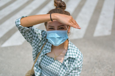 Young women wearing medical protection mask stay on the city street