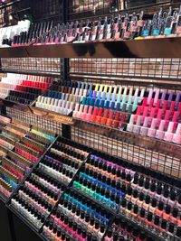 Full frame shot of multi colored nail polish bottles arranged in shop