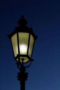Low angle view of illuminated street light against clear sky