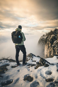 Rear view of man standing on snow covered landscape