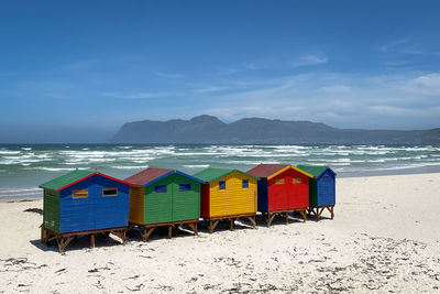 Multi colored umbrellas on beach against sky