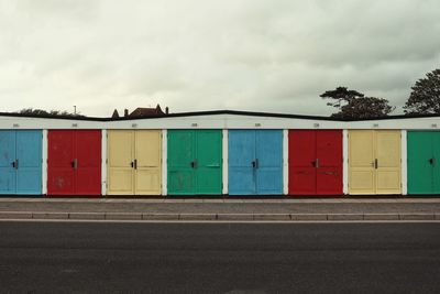 Multi colored building by road against sky