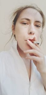 Close-up portrait of woman smoking cigarette