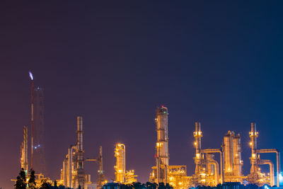 Illuminated industrial building against clear sky at night