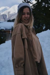 Portrait of young woman standing on snow