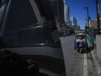 Vehicles on road amidst buildings in city